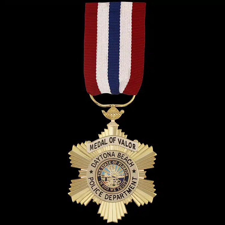 Gold star-shaped medal with a full colour seal at its centre, hanging from a red, white and blue striped drape ribbon.